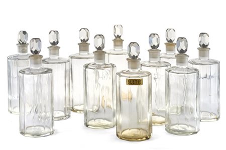 Ventitrè bottiglie per profumi in vetro sfaccettato con tappi in vetro molato,