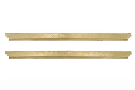Coppia di insegne in ottone di forma sagomata del marchio di profumeria di luss