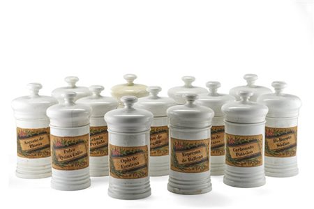 Tredici vasi da farmacia di misure differenti in ceramica bianca con coperchi d