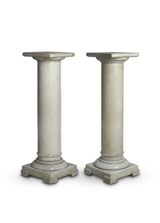 Coppia di colonne in marmo bianco con capitello squadrato e basamento con piedi