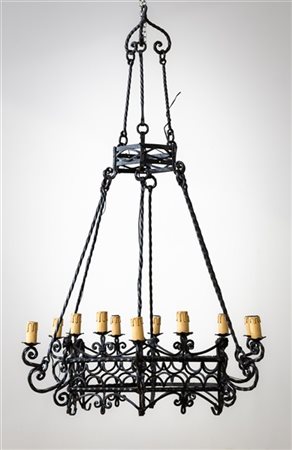 Lampadario in ferro battuto a dodici luci. Inizio secolo XX (h. cm 125, senza c