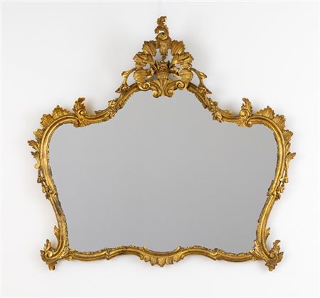 Caminiera in legno intagliato e dorato di forma sagomata con decorazione a moti