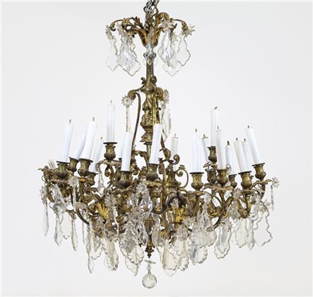 Grande lampadario a ventuno luci in bronzo dorato con bracci a volute fogliacee