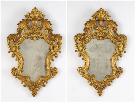 Coppia di specchiere di forma mossa con cornici in legno intagliato e dorato co