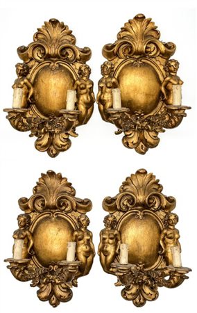Gruppo di quattro applique in legno intagliato e dorato a due luci decorata a v