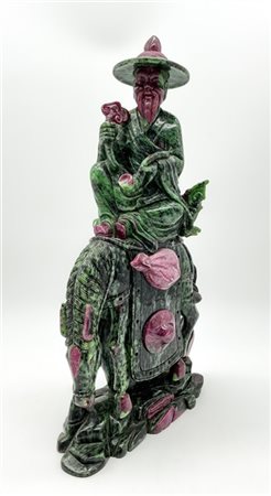 Scultura di saggio a cavallo a tutto tondo in rubino-zoisite. 
Cina, secolo XX