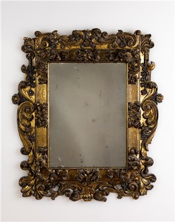 Specchiera con cornice in legno intagliato e dorato di forma rettangolare con r