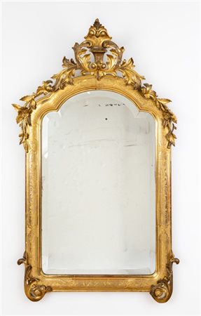 Specchiera in legno intagliato e dorato di forma sagomata con fascia bulinata,