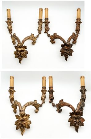 Gruppo di quattro antiche applique a due luci in legno intagliato e dorato con