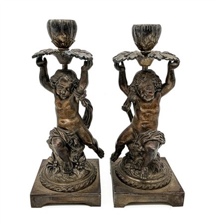 Coppia di candelieri in bronzo argentato con portacandela sorretta da putti. Se
