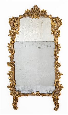 Specchiera con cornice in legno intagliato e dorato a volute contrapposte e mot