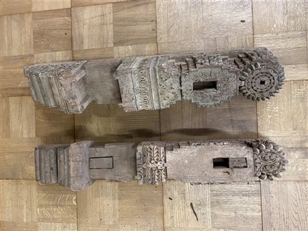 Lotto composto da due capitelli di portale in legno intagliato con decori stili