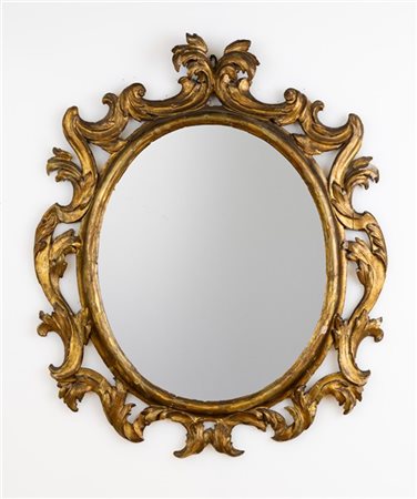 Specchiera di forma ovale con cornice in legno intagliato e dorato a volute fog