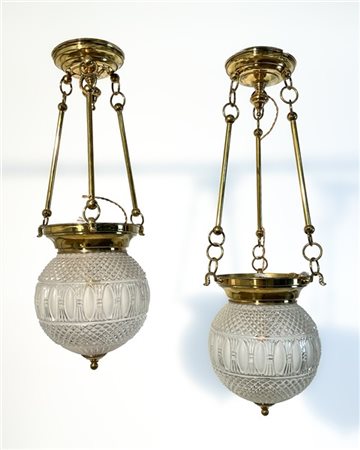 Coppia di lampadari in ottone con tre pendenti e plafoniera in vetro stampato.
