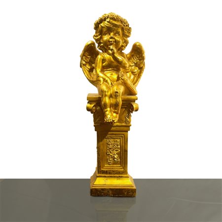 Putto dorato seduto su una colonna
