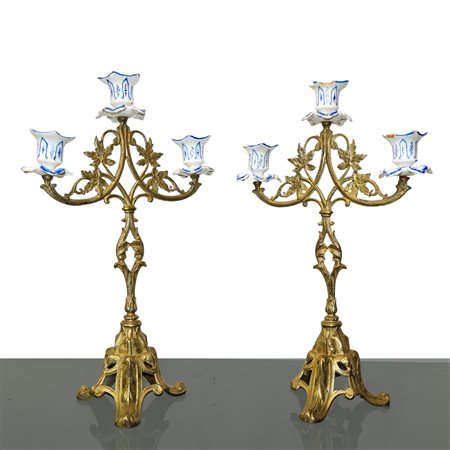 Coppia di candelabri a tre luci in metallo dorato e porcellana