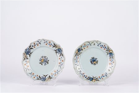 Coppia di piatti in maiolica policroma, decorati a motivi floreali