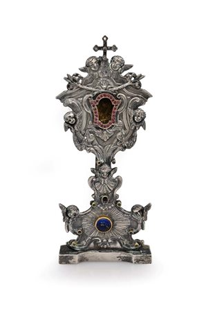  
Piccolo reliquiario a ostensorio in fusione d'argento con gemme multicolore, XIX secolo 
 cm 21x8,5x6 - peso complessivo gr. 300