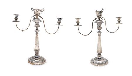 
Coppia di antichi candelabri a doppio uso in argento di gusto neoclassico 
 cm 49x44x16,5 - singolo h cm 37 - peso complessivo gr. 1.960