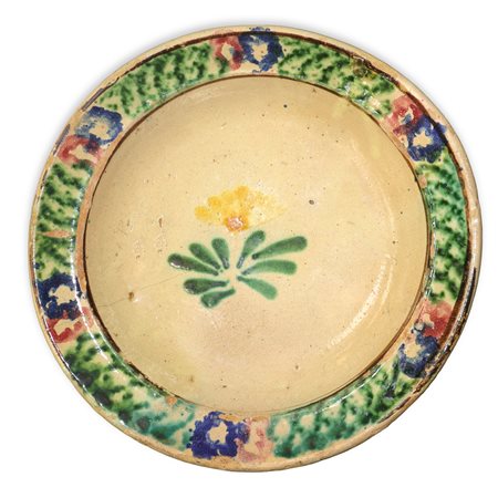 Piatto in maiolica di Caltagirone con bordo spugnato e fiore policromo al centro, Primi 20°  