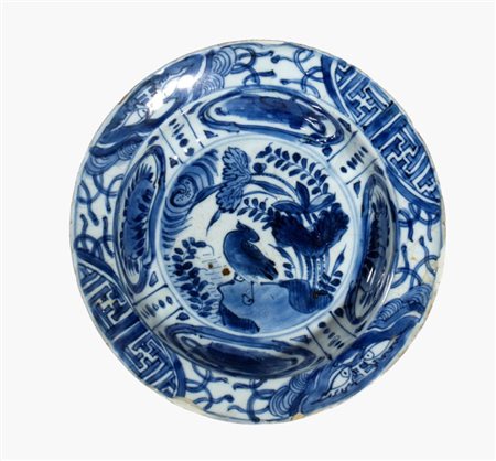  
Piatto in porcellana Kraak bianca e blu, decorato con motivi floreali e uccelli al centro, bordo a pannelli. Cina, dinastia Ming, fine XVII secolo 
 Altezza cm 5,5; diametro cm 20,3