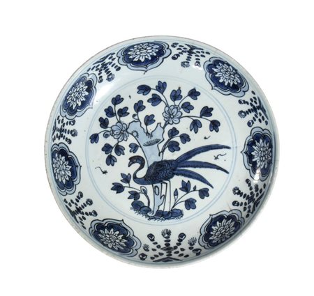  
Piatto in porcellana Kraak bianca e blu decorato con phone, rami e motivi floreali. Cina, dinastia Ming, XVII secolo 
 Diametro cm 26; altezza cm 5,6