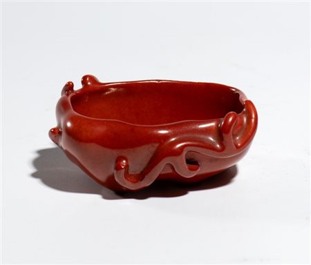  
Importante catino per pennelli a forma di foglia di loto con racemi vegetali a tutto rilievo in porcellana con smalto rosso corallo. Cina, dinastia Qing. periodo Yongzheng-Qianlong
