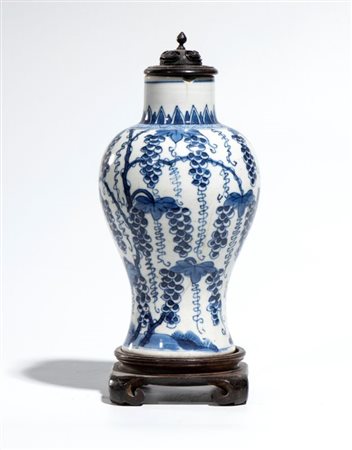  
Vaso a balaustro in porcellana bianca e blu con decorazione sottosmalto raffigurante tralci e grappoli d’uva pendenti. Cina, dinastia Qing, periodo Kangxi 
 Altezza cm 17,8; diametro cm 10