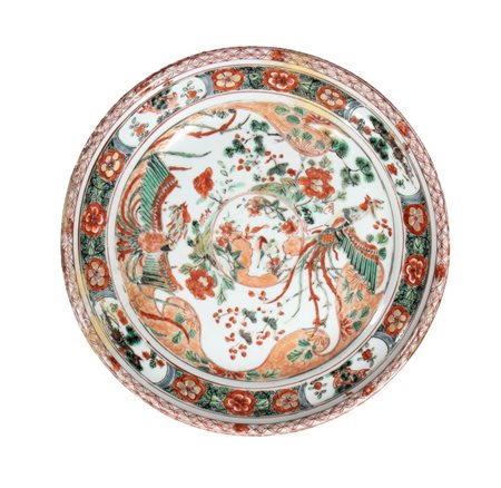  
Piatto in porcellana famiglia verde a smalti decorato con fenici stilizzate tra rami fioriti e medaglioni floreali. Cina, dinastia Qing, periodo Kangxi 
 Diamtero cm 22,3; altezza cm 4