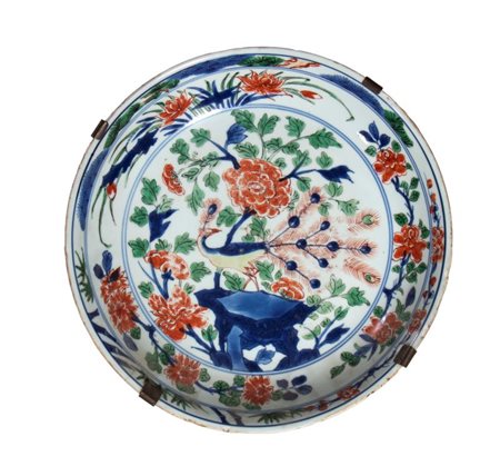  
Piatto in porcellana dipinto a smalti policromi con fenici e pavoni in mezzo a rocce. Cina, dinastia Qing, XVII-XVIII secolo 
 Diametro cm 27,4; altezza cm 5,8