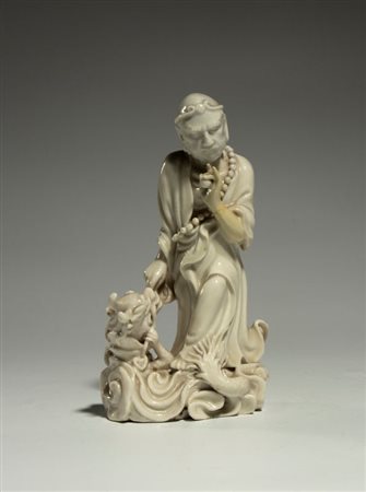  
Figura in porcellana Dehua "Blanc de Chine" raffigurante Damo (Bodhidharma) in posa da "Vincitore del Drago" (Xianglong Luohan). Cina, XX secolo 
 Altezza cm 13,5; larghezza cm 7