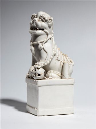  
Cane di Fo in porcellana Dehua "blanc de Chine" raffigurato con la zampa su una sfera. Dinastia Qing, fine XVIII-XIX secolo 
 Altezza cm 27,5 