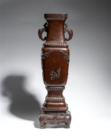  
Vaso in bronzo fuso a patina marrone scuro, corpo quadrato e manici zoomorfi. Periodo Meiji. Giappone, seconda metà del XIX secolo 
 Altezza cm 44; con base cm 10 