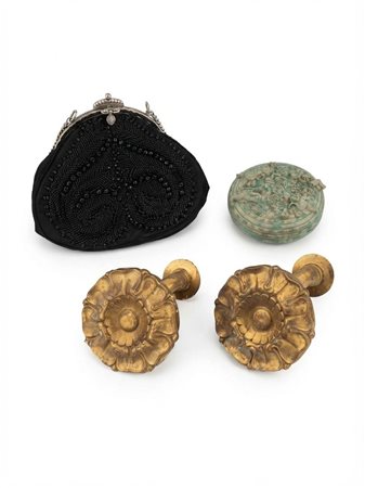 Una collezione di oggetti decorativi comprendente una borsa da sera con perline, una scatola circolare figurata e una coppia di rosette in metallo dorato
