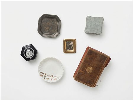 Una collezione di oggetti decorativi e oggetti da collezione tra cui una scatola esagonale Tristesse