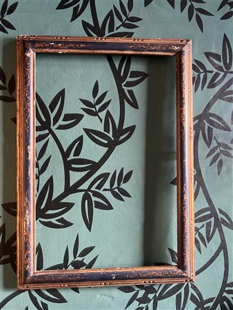 Cornice rettangolare in legno ebanizzato e dorato con decoro a girali fogliacei