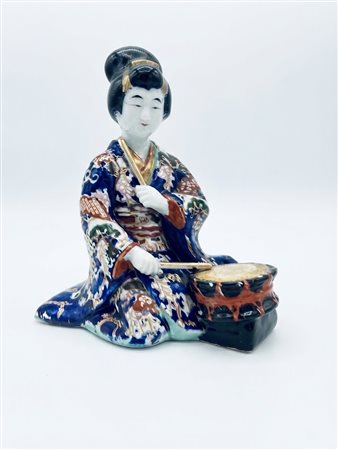 Statuina in porcellana policroma raffigurante musicista con tamburo shime-daiko, Altezza 19 cm.