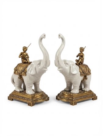 Coppia di elefanti decorativi in ceramica craquelé e bronzo dorato con putti, ,Altezza: 37 cm.  Dimensioni: cm 39 x 27 x 16.