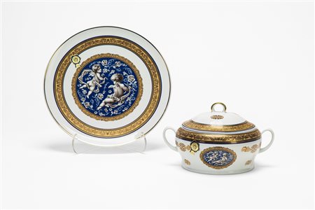 Zuppiera biansata con piatto in porcellana con profili blu e dorati decorati a girali di foglie. Limoges.