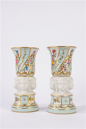 Coppia di vasi in porcellana con teste di putti in biscuit