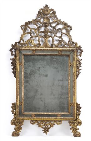 Specchiera in legno intagliato e dorato con elementi laterali a foglie e fiori,