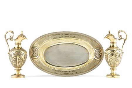 Coppia di ampolline in vermeil inciso e sbalzato con decoro a tralci d'uva, pam