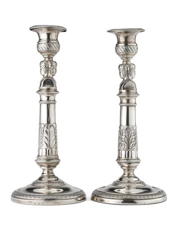 Coppia di candelieri in argento con fusti a colonna decorati a foglie e sormont