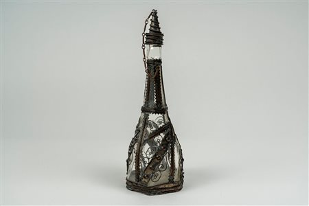 Bottiglia con tappo in vetro incolore a base esagonale montata in metallo argentato lavorato a filigrana. Probabilmente Turchia, secolo XIX