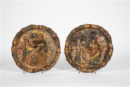 Coppia di medaglioni in cartapesta su tela calcata raffiguranti Visitazione e Natività entro ghirlande alla robbiana. Toscana, fine XVI secolo.