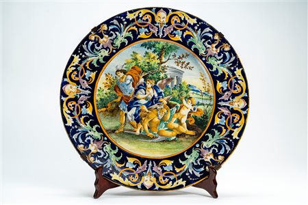 Piatto da parata in maiolica policroma a grottesche e istoriata con scena allegorica raffigurante la Storia con Mercurio e il Tempo. Manifattura del secolo XIX.