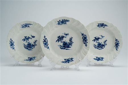 Tre piatti in porcellana a bordo mosso e costolato a rilievo con decoro floreale all'orientale in blu di cobalto. Possibilmente Belgio, Tournai, seconda metà secolo XVIII
