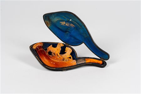 Pipa in schiuma di mare intagliata raffigurante scena di caccia. Entro custodia sagomata. Secolo XIX
