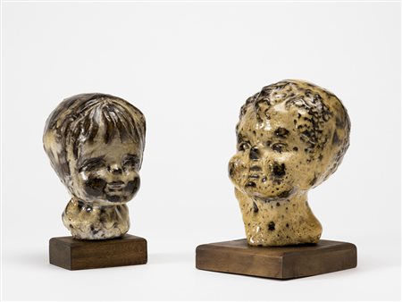 Lotto di due teste di fanciullo in ceramica invetriata montate su base in...