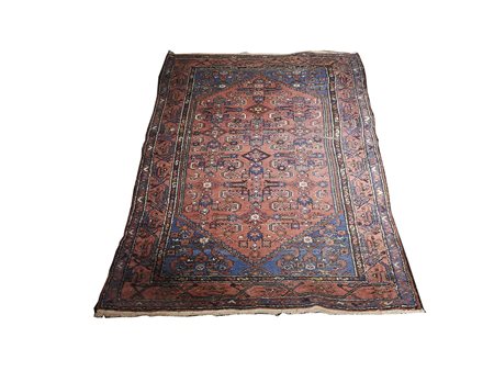 Tappeto caucasico fondo rosso mattone, campo con disegni geometrici nei toni...